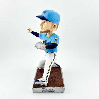 Bobblehead of baseball player in blue uniform throwing a ball against a white background. 