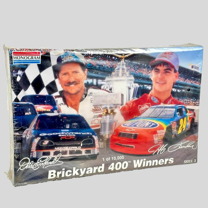 Model car kit packaging featuring two race cars and a checkered flag, with 'Monogram' branding.