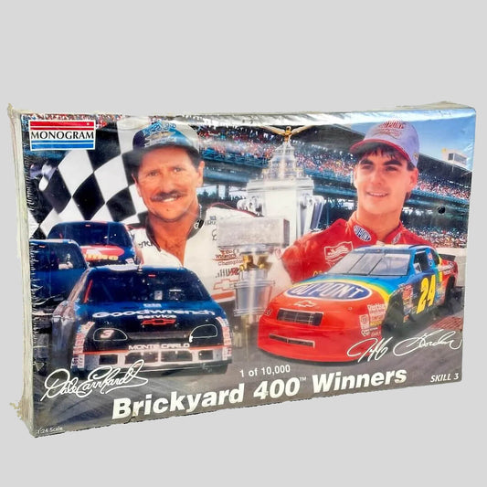 Model car kit packaging featuring two race cars and a checkered flag, with 'Monogram' branding.
