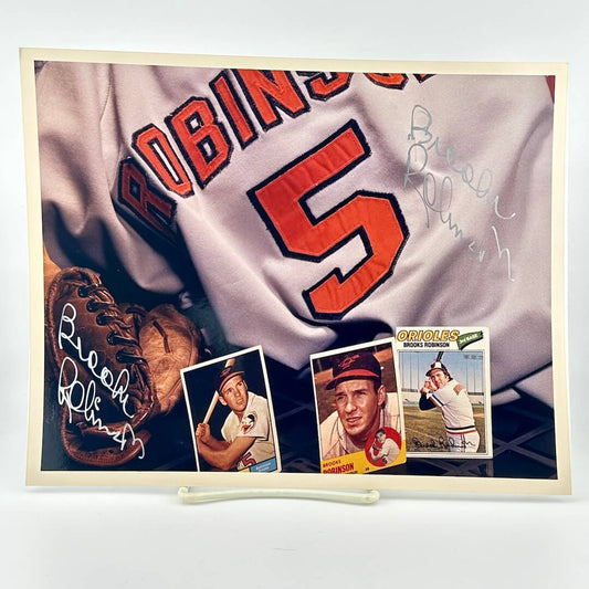 Photo of arranged baseball memorabilia featuring Brooks Robinson and two of his signatures. 