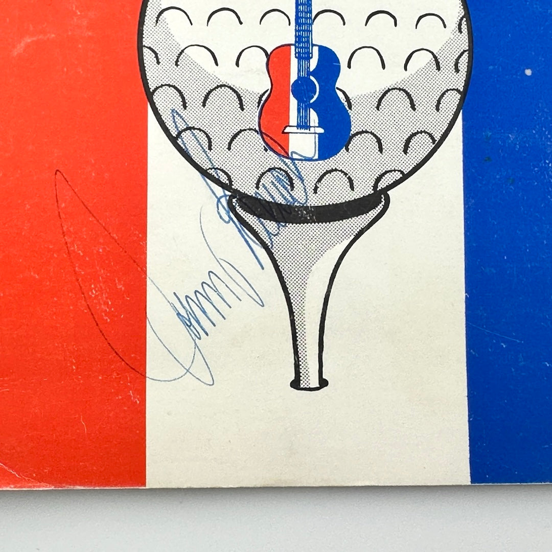 Close-up of blue pen ink signature of Johnny Bench across golf tee at bottom center of book. 