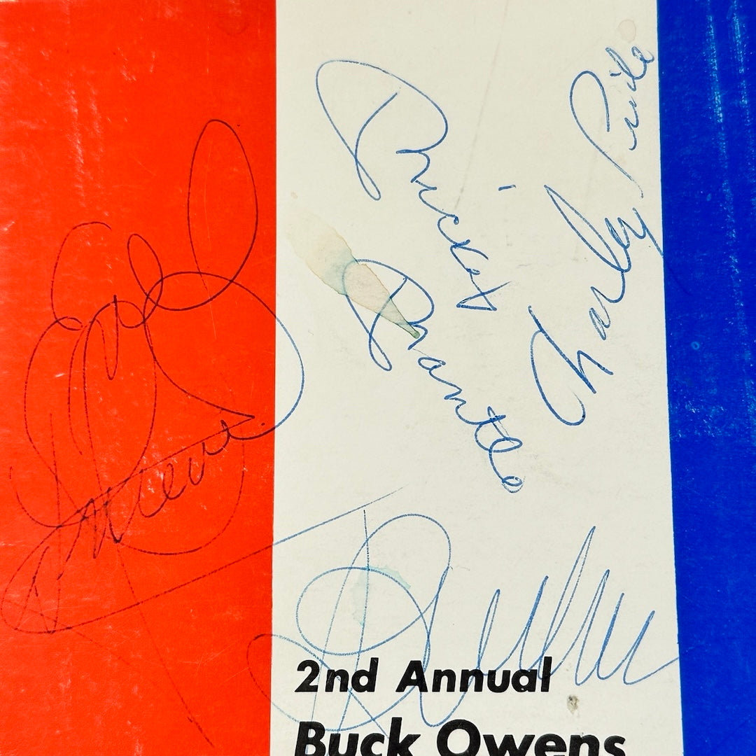 Close-up of blue pen ink signatures of Mickey Mantle, Charley Pride, Evel Knievel, & Buck Owens. 