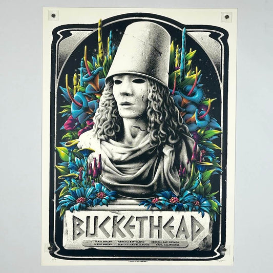 Poster of a statue with a bucket on its head surrounded by colorful foliage, featuring the artist 'Buckhead'.
