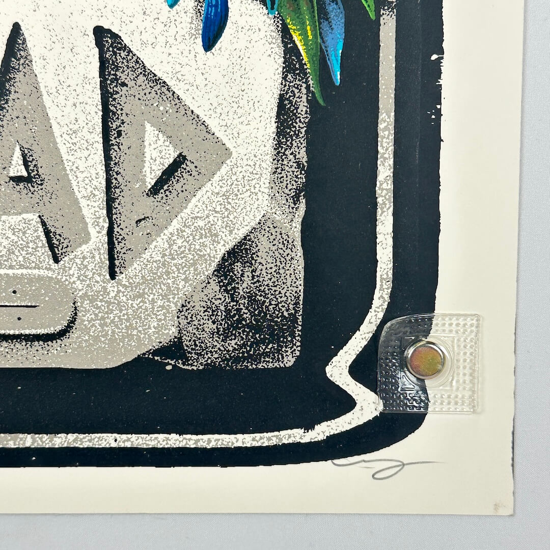 Bottom right corner of poster showing sharp corner, some ink to edge from printing, and artist signature in pencil. 