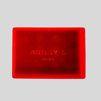 Red plastic rectangle with 'Buddy L Japan' branding on a light background