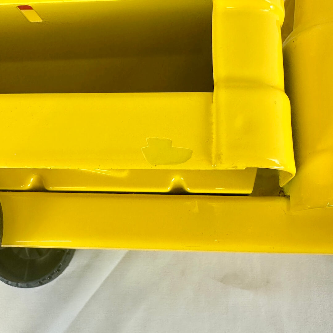 Close up of side of toy yellow truck to show repainted spot. 