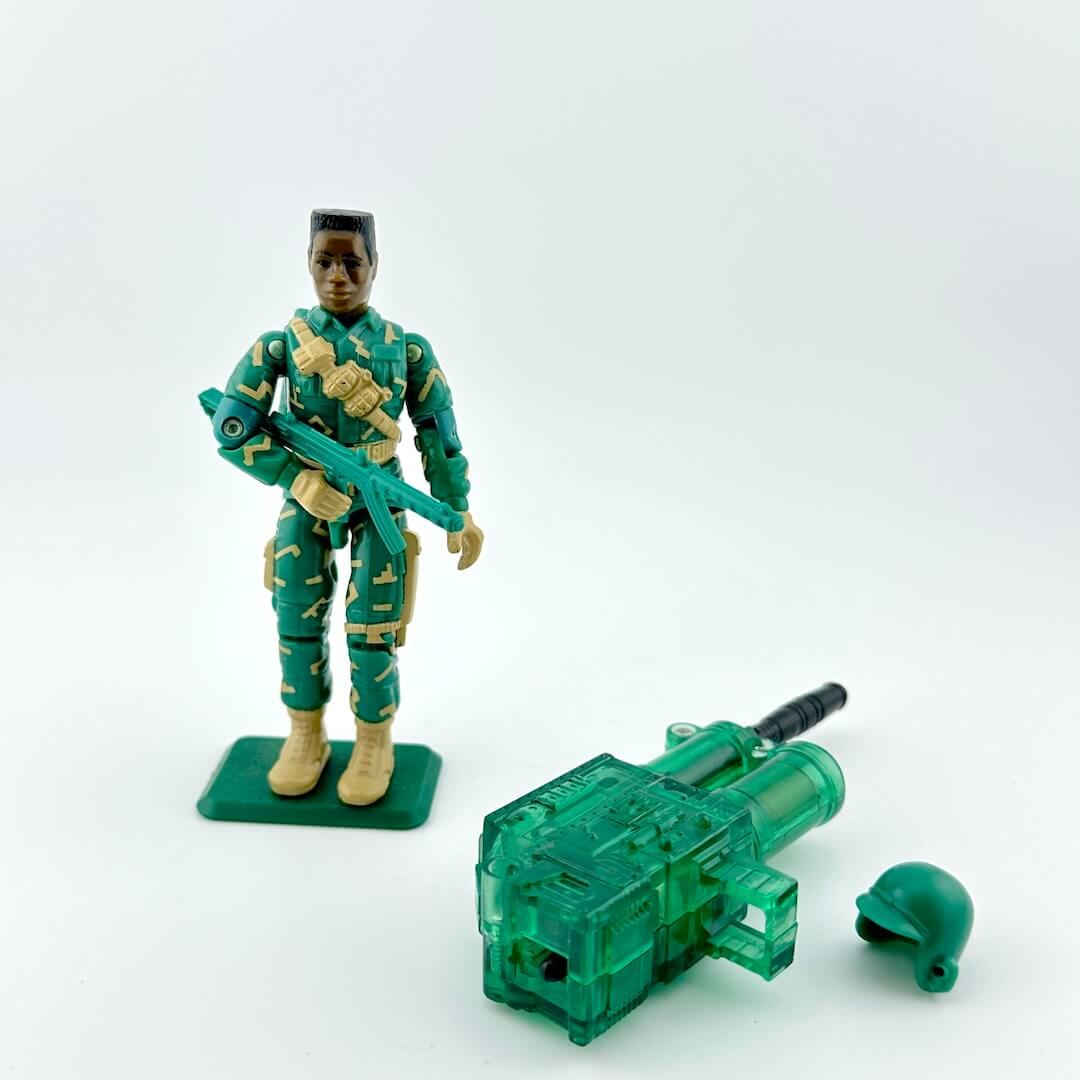 Toy soldier in green camouflage uniform with a transparent green gun on a white background