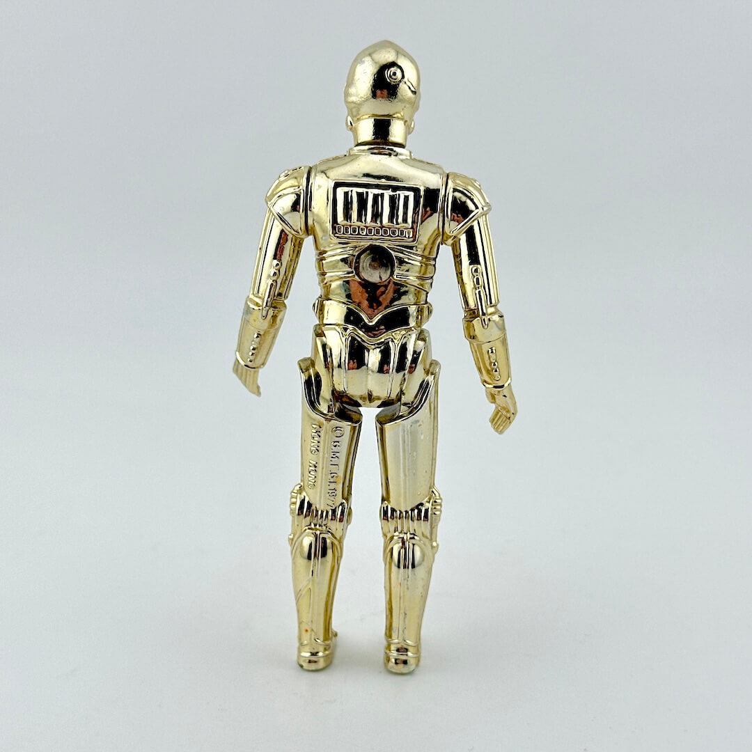 Gold robot toy figure on light gray background.