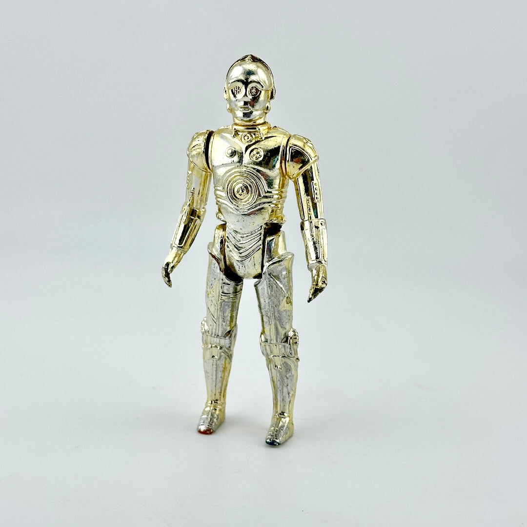 A metallic gold C-3PO droid action figure standing against a light gray studio background.