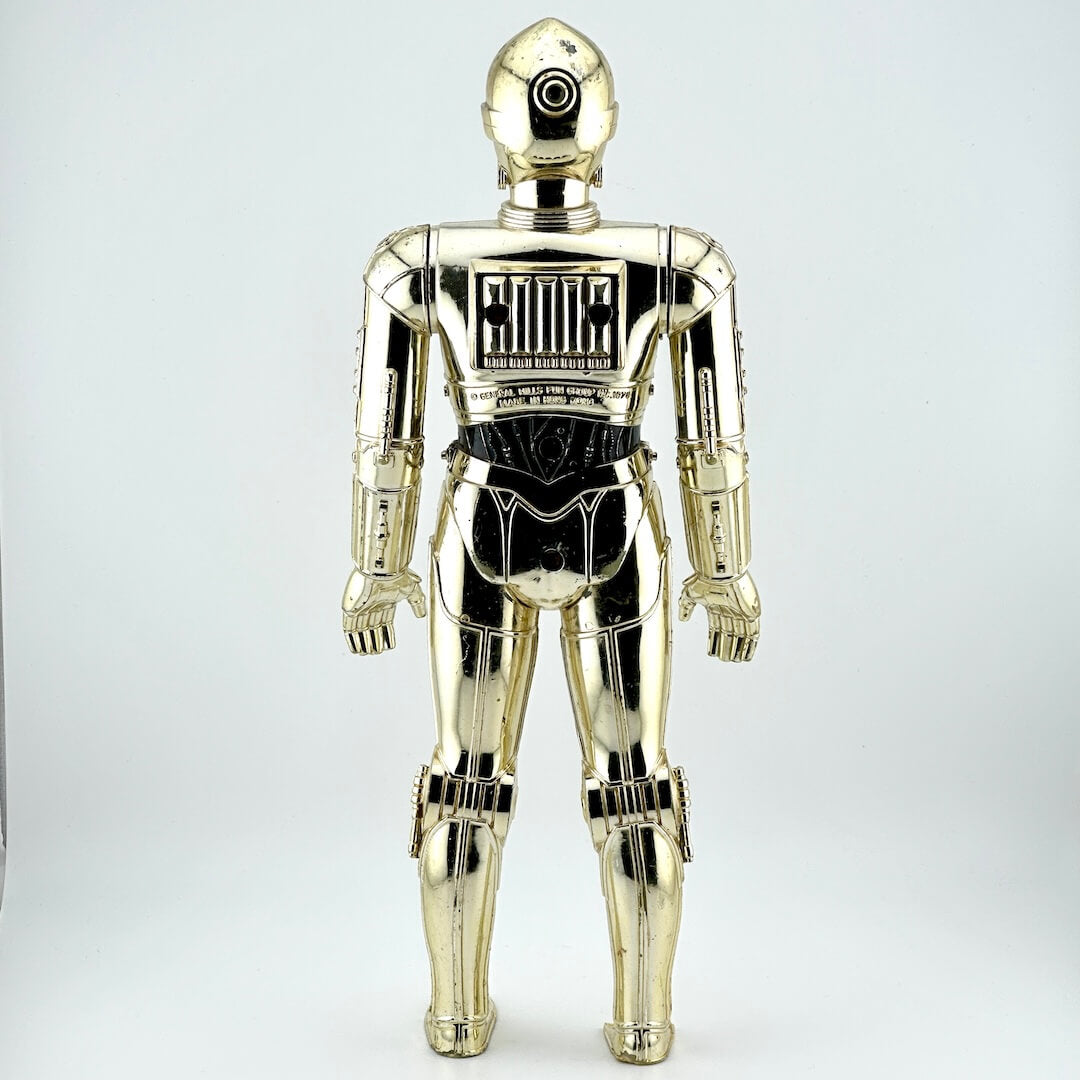 Plastic figure of gold/silver robot with broken left foot against white background. 