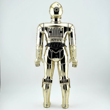 Plastic figure of gold/silver robot with broken left foot against white background. 
