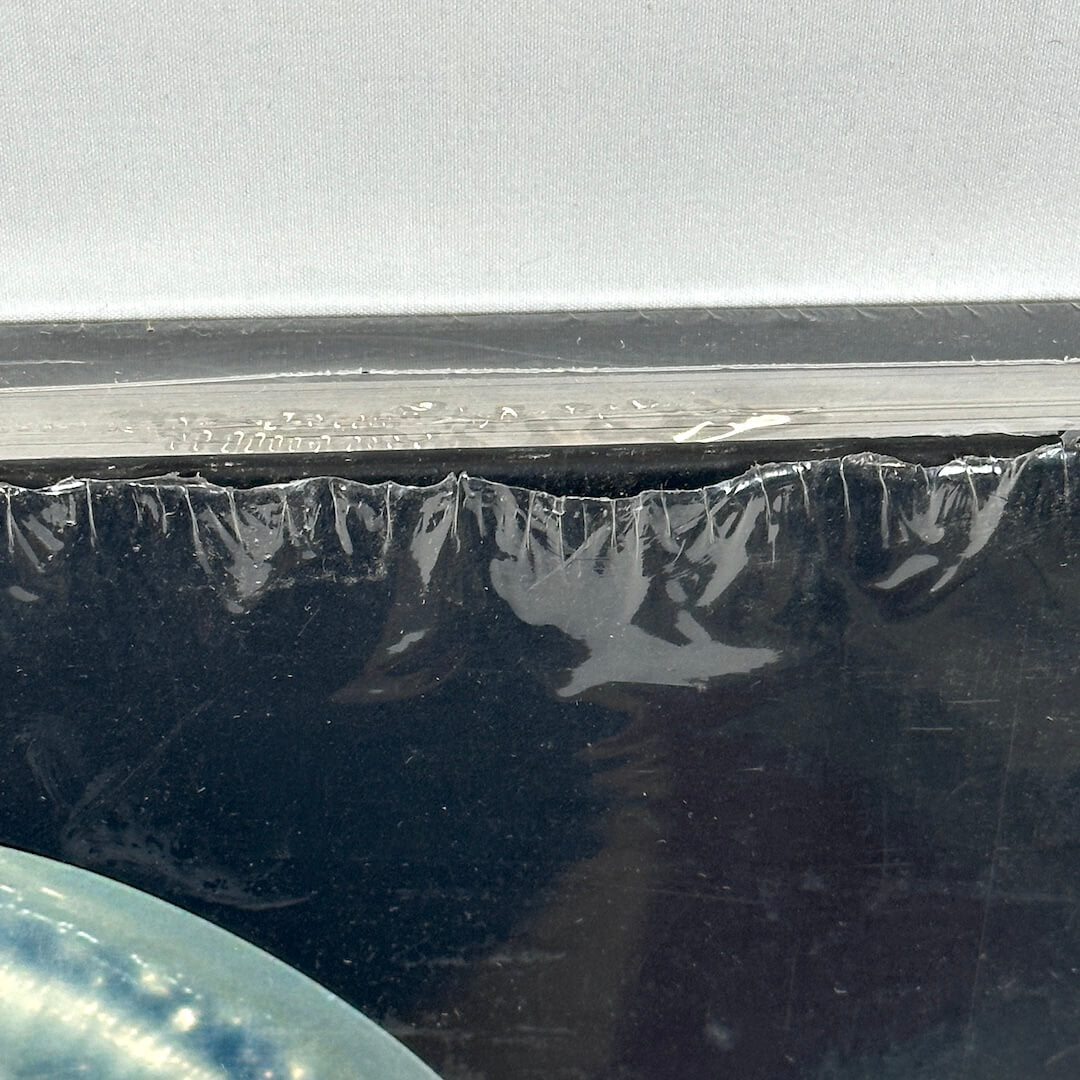 Close up of opening in shrink wrap at top of book. 