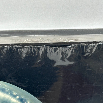 Close up of opening in shrink wrap at top of book. 