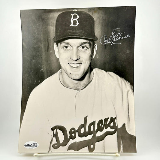 Black and white photo of a baseball player in a Dodgers uniform with a cap, signed by Carl Erskine.