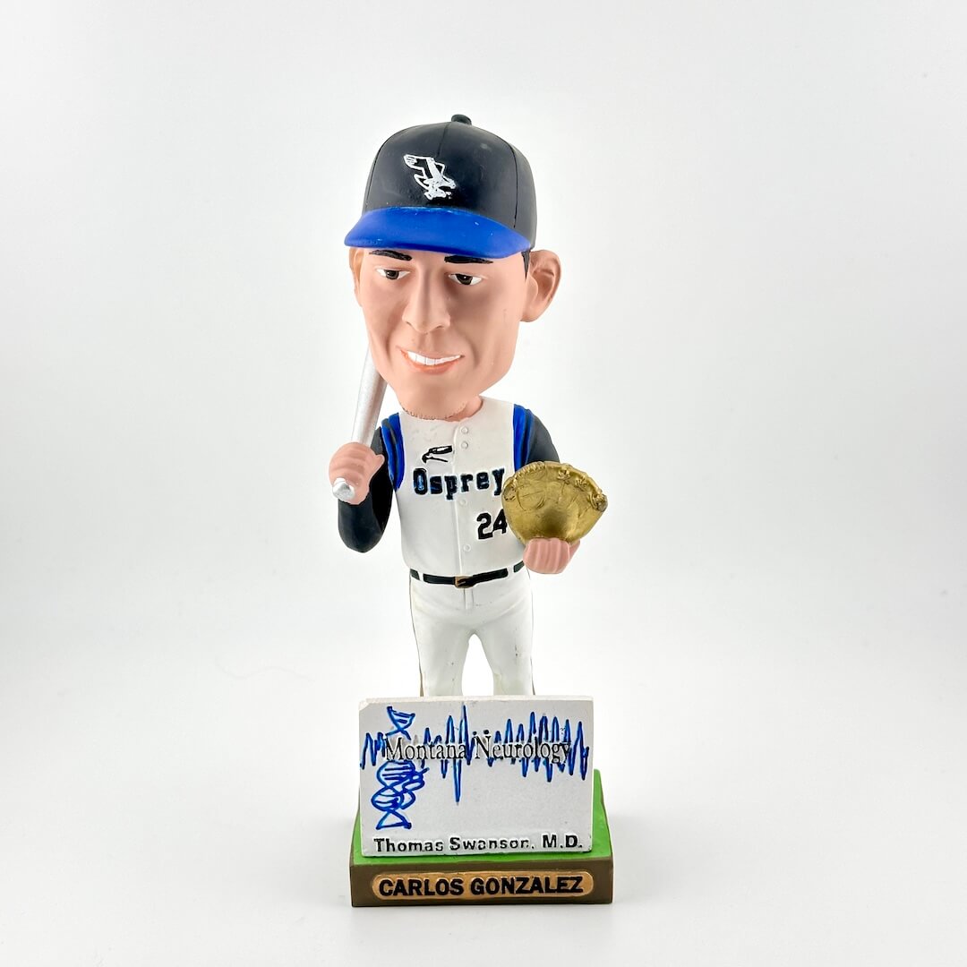 Bobblehead figure of a baseball player holding a bat and glove, with a white background