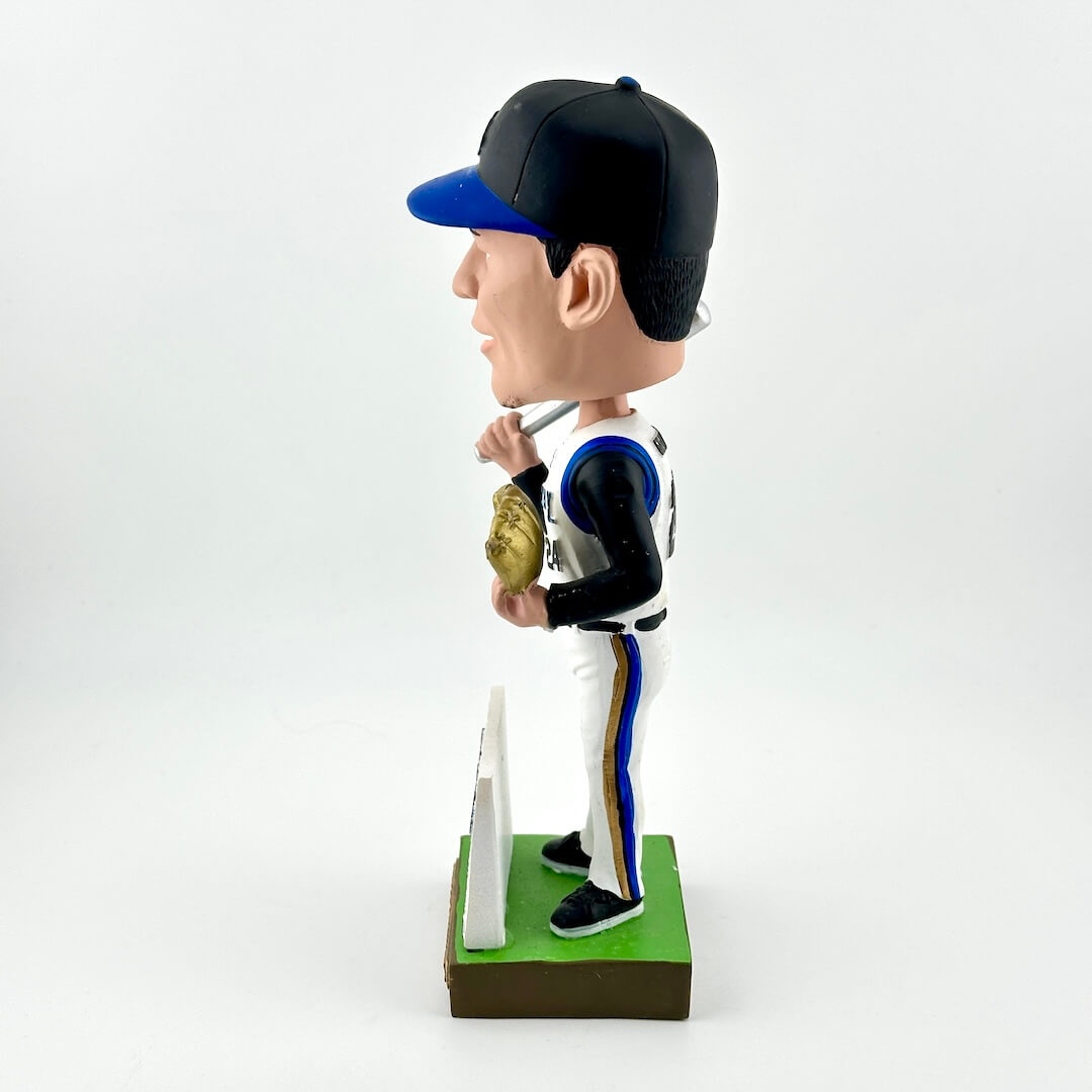 Bobblehead figure of a baseball player in a uniform with a bat and glove on a white background