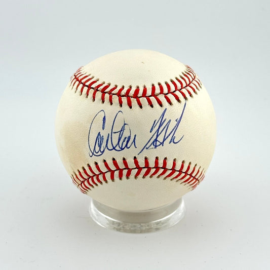 Baseball with autograph on a clear stand against a light gray background