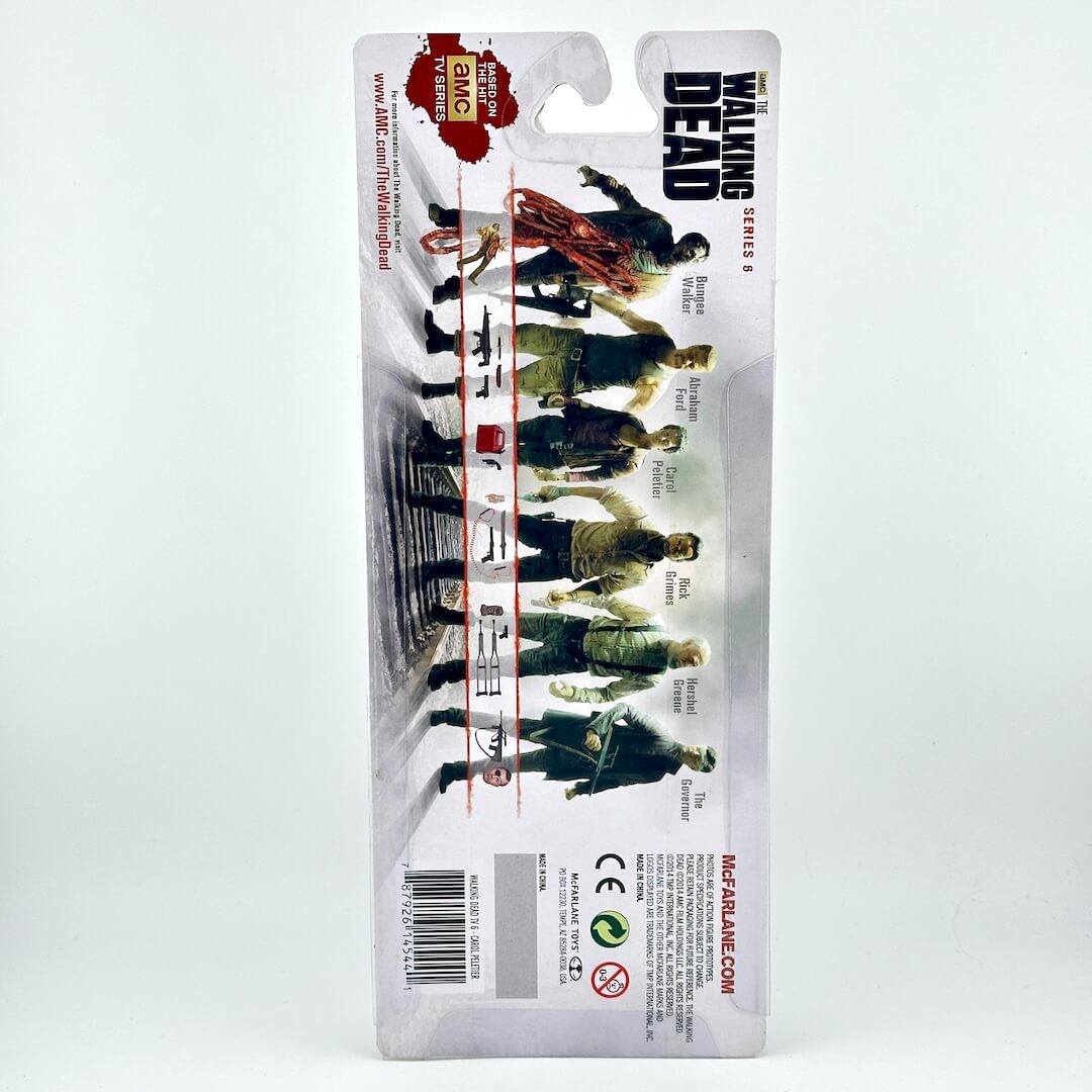Back view of a packaged action figure on a white background. 