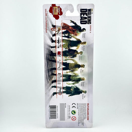 Back view of a packaged action figure on a white background. 