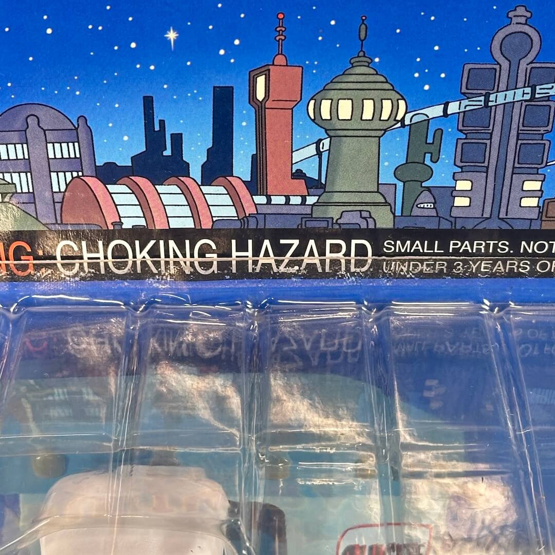Toy packaging with a futuristic cityscape background and 'Choking Hazard' warning label.