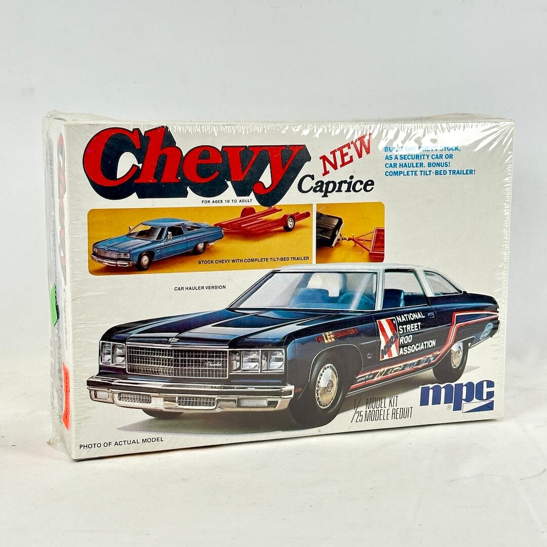 Box with vintage model kit for Chevy Caprice against white background. 