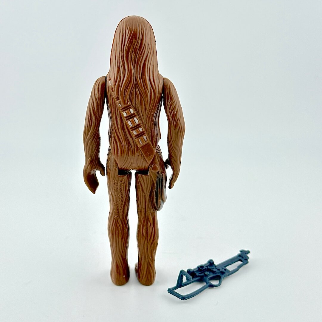 Toy figure of a character with a blue tool on a white background