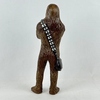 Brown furry creature figure with a black and white striped strapped bag on a white background