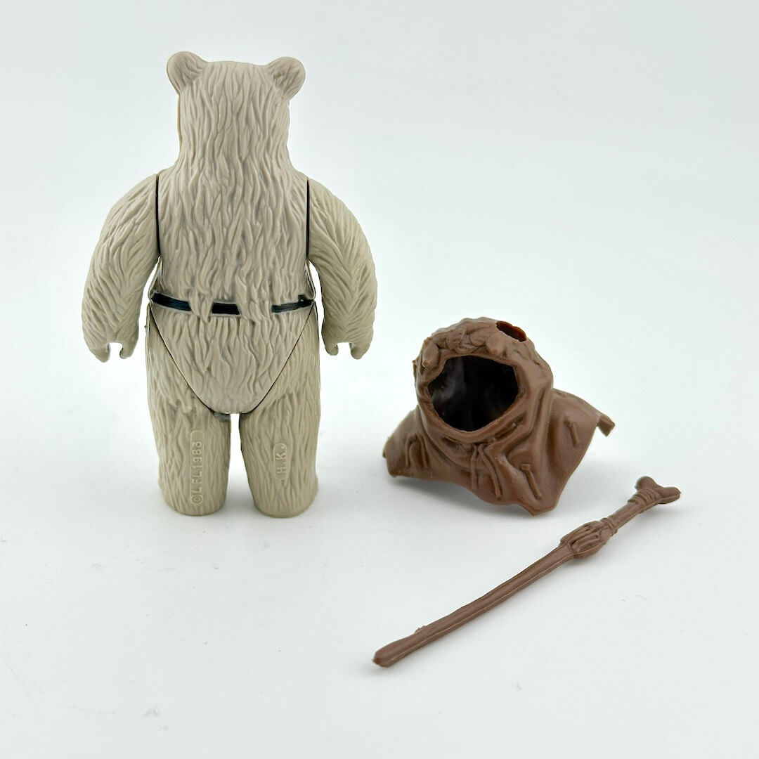 Toy figure of a character with a hat, robe, and staff on a white background