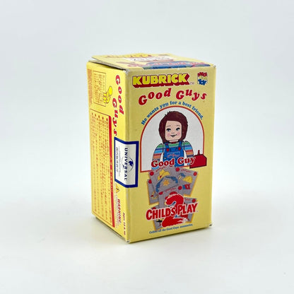 A yellow box of Kubrick Good Guys Child's Play 2 mini-figures, featuring an illustration of Chucky.