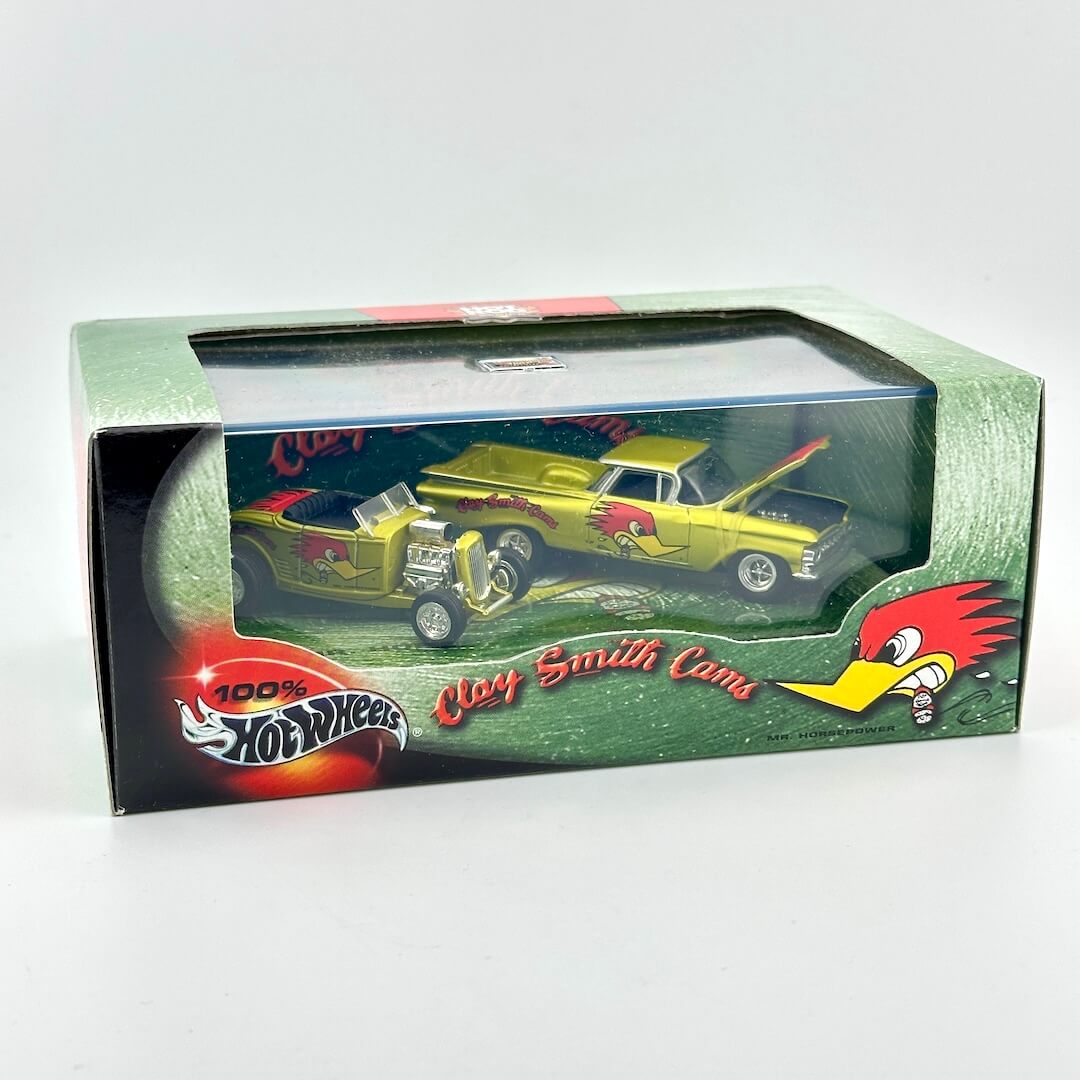 A boxed Hot Wheels die-cast toy car set on a plain light background. The packaging is green with a clear window.