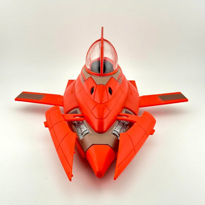 A red toy spaceship with gray panels and a clear canopy, photographed on a plain light gray background.