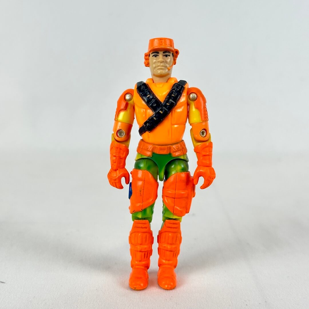 GI Joe action figure in orange vest, green pants with orange boots and helmet, standing against white background. 
