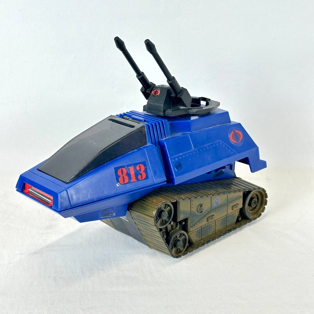 Blue and black toy tank with gun turret pictured against white background. 