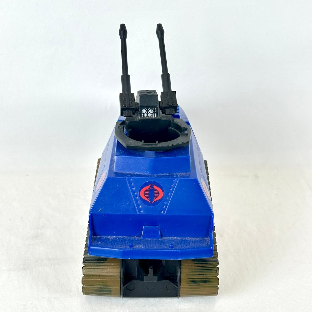 Back view of blue and black toy tank with olive green treads on white background. 