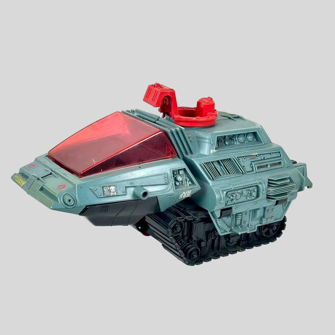 A toy tank vehicle with a light blue-gray body, a translucent red canopy, and black tracks, photographed on a plain light background.