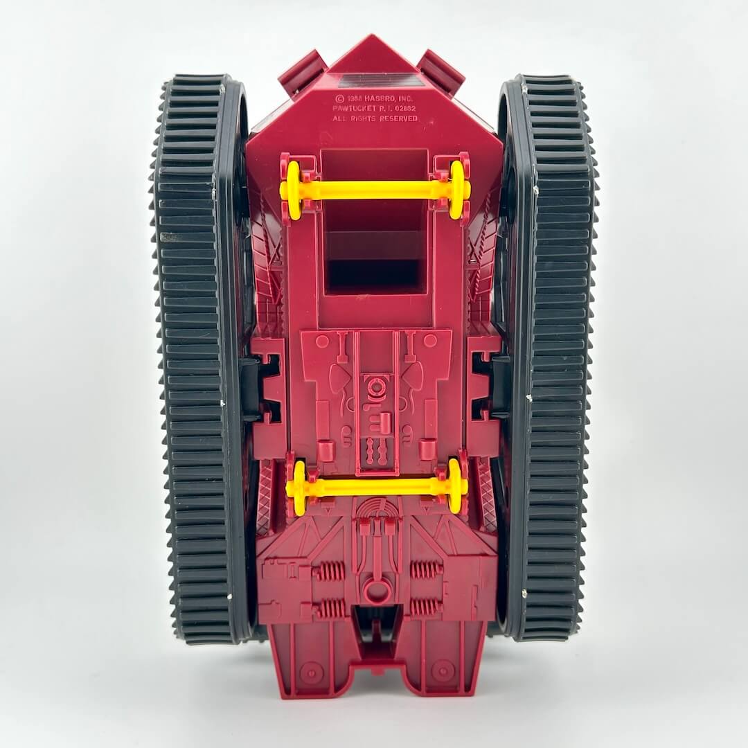 Red toy vehicle with black wheels and yellow axles on a white background