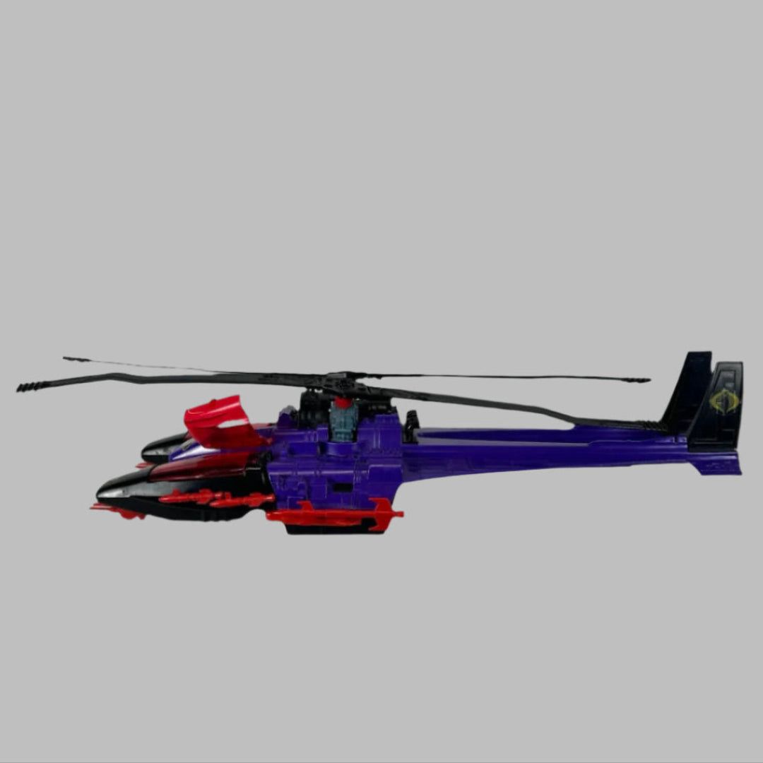 Purple & red toy helicopter with two black blades & tailfins, red missiles along side.