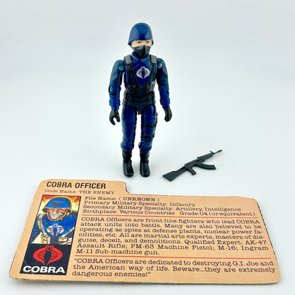Cobra action figure with character card and gun accessory on white background. 
