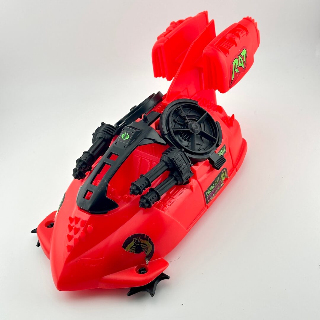 Red and black toy vehicle against white background. 