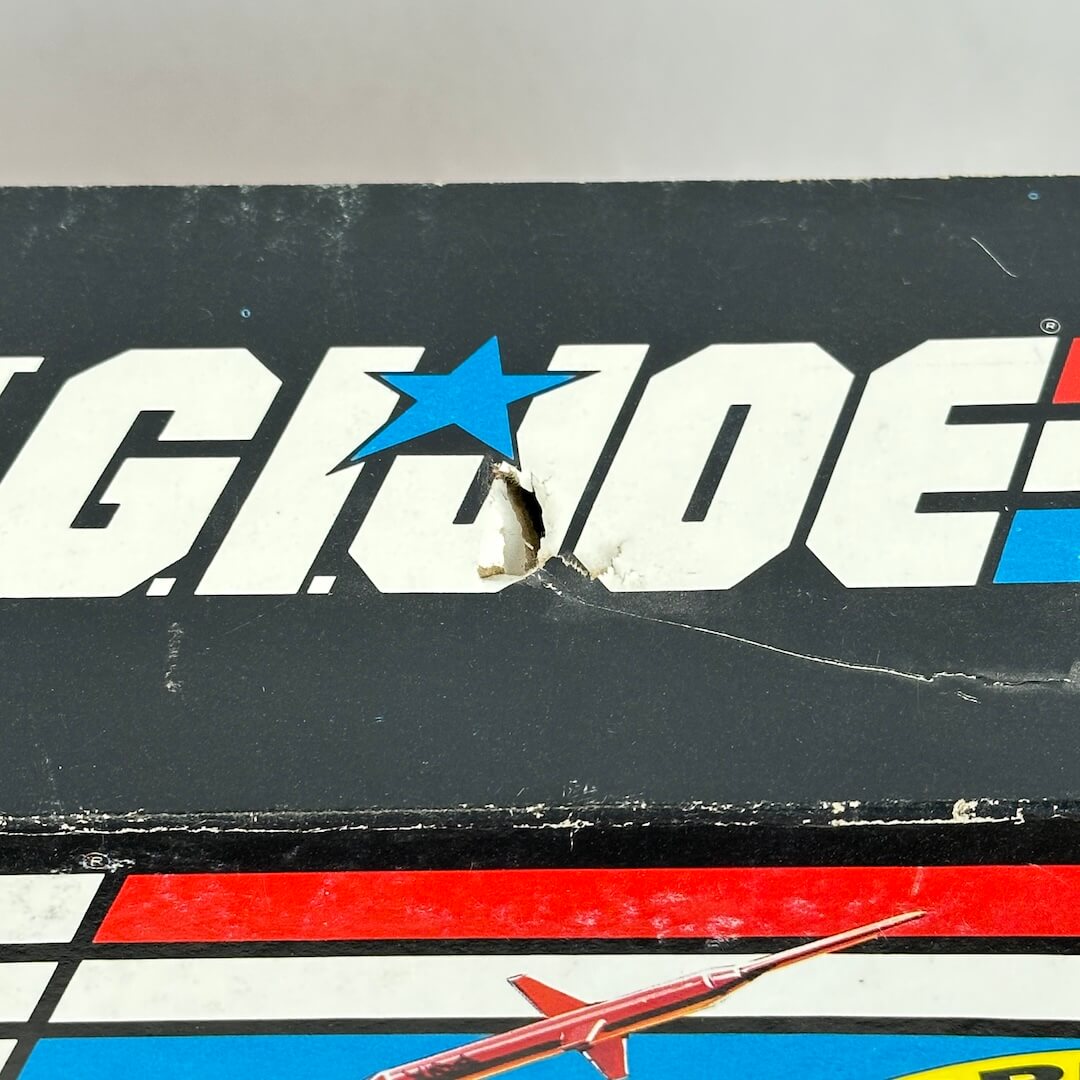 Vintage G.I. Joe toy box with branding and a small model airplane on a white background