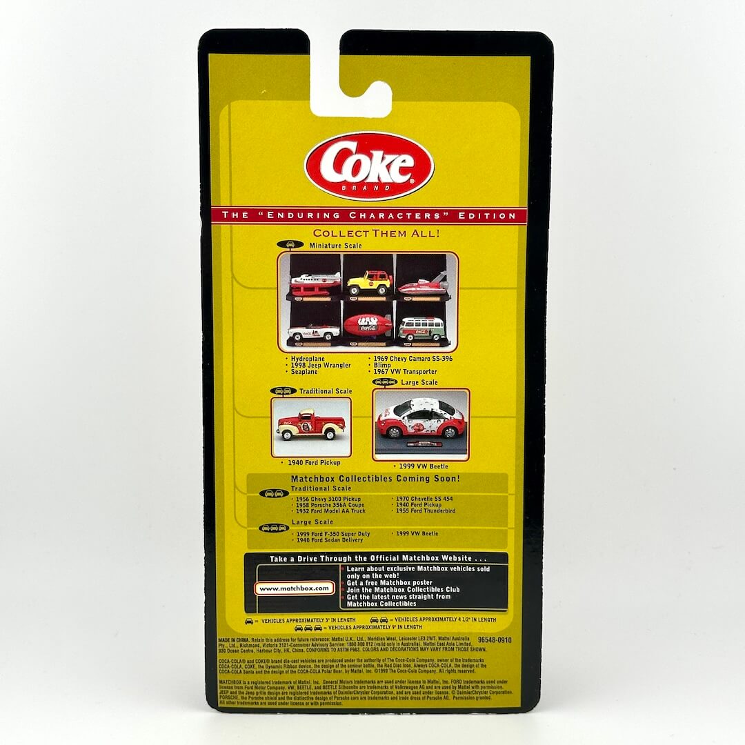 Packaged collectible diecast model car in its yellow and black retail blister card packaging, featuring the Coca-Cola logo.