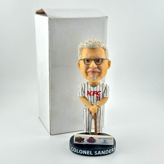 Bobblehead of a man in a KFC uniform with a white background