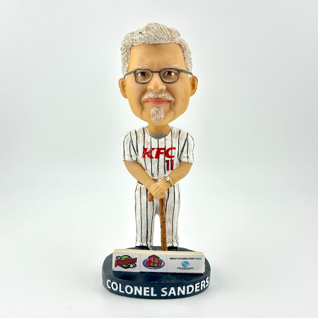 Bobblehead figure of a man in a KFC uniform with a white background