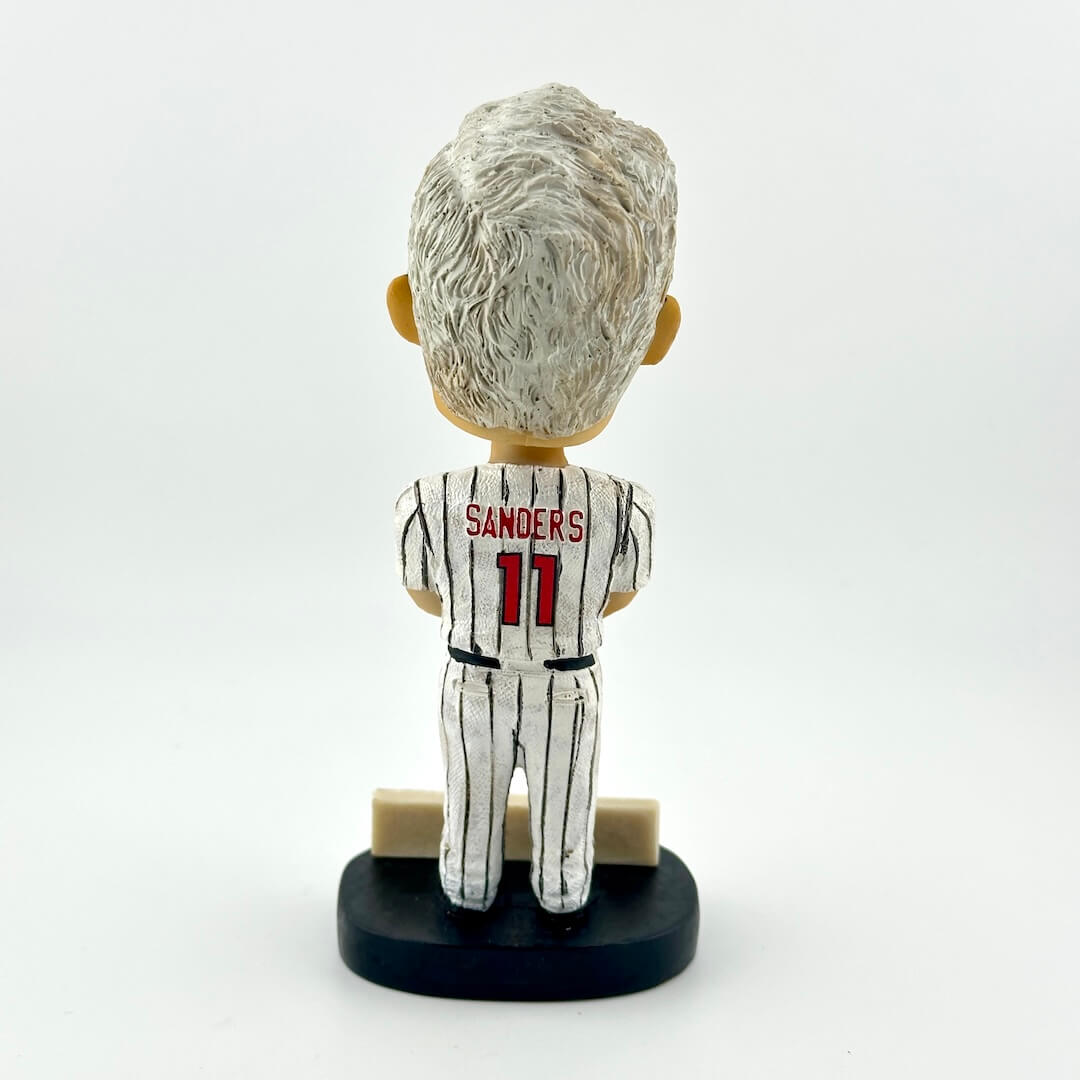 Bobblehead figure of a sports player in a white uniform with red accents on a white background