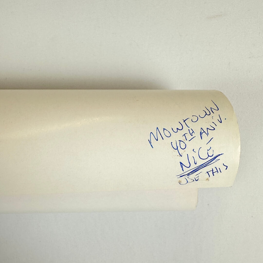 Roll of paper with handwritten text on a plain background