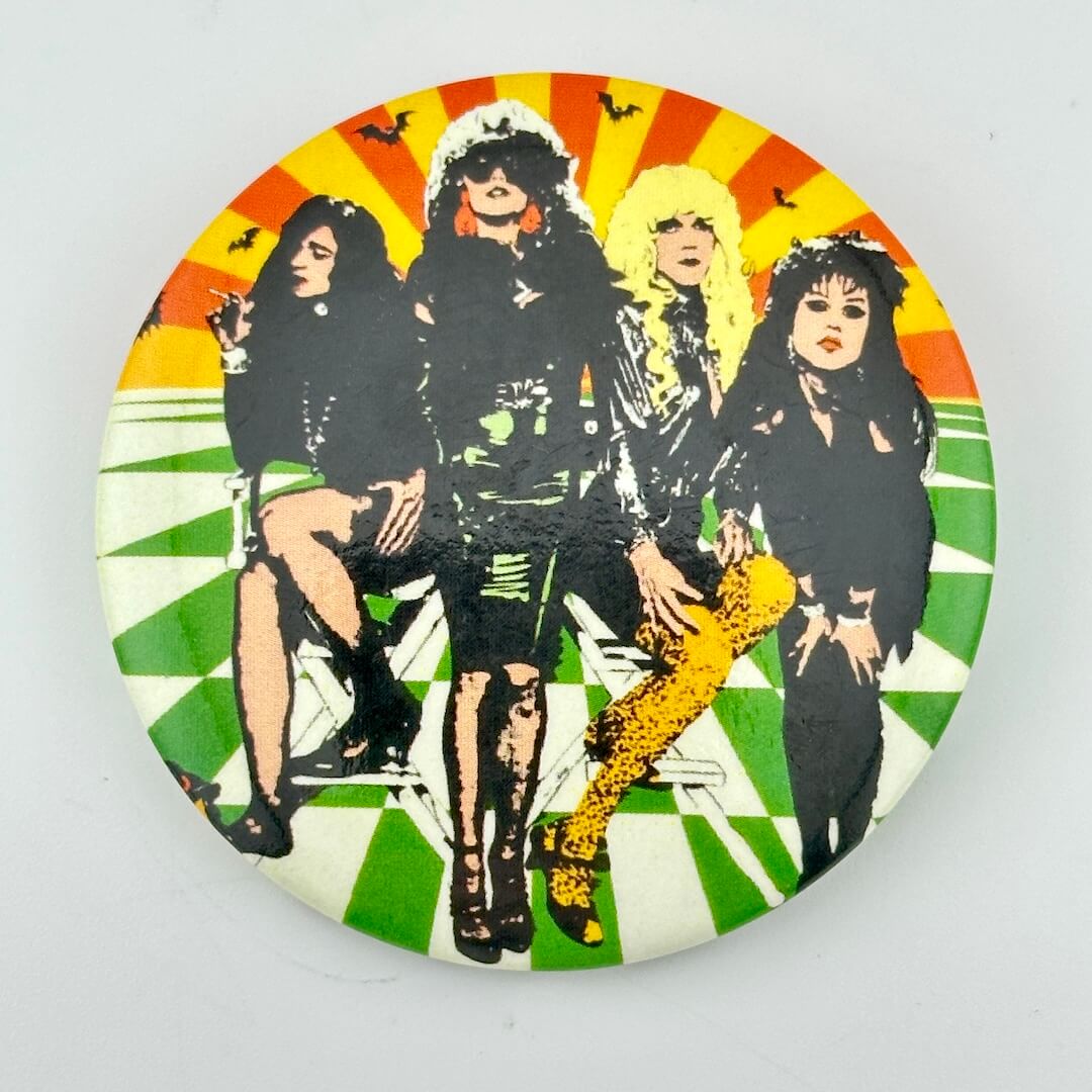 Pin with four women in black on checkered background. 