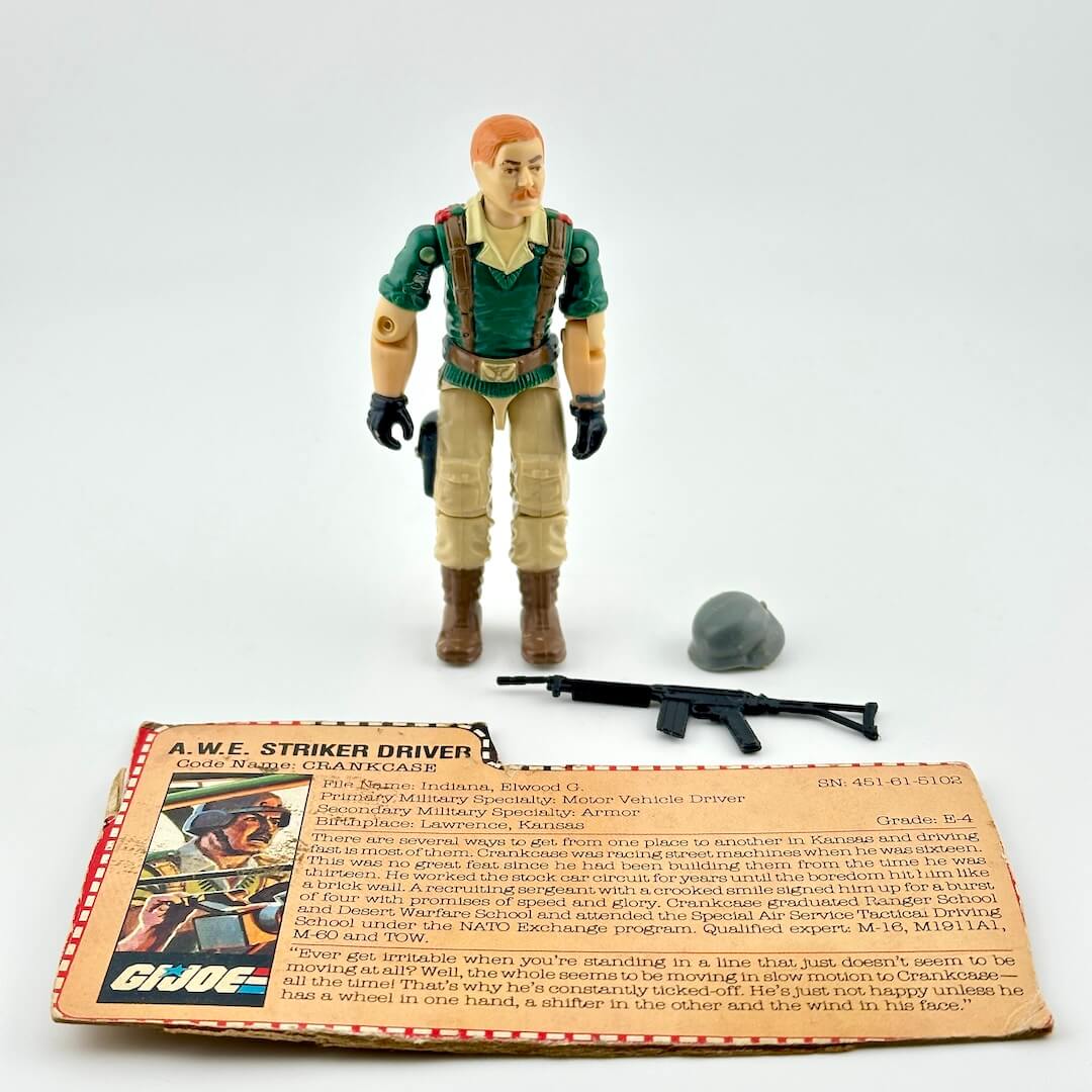 GI Joe action figure with accessories and card against white background. 