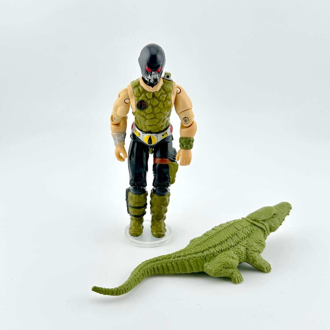 Action figure with a green crocodile toy on a white background