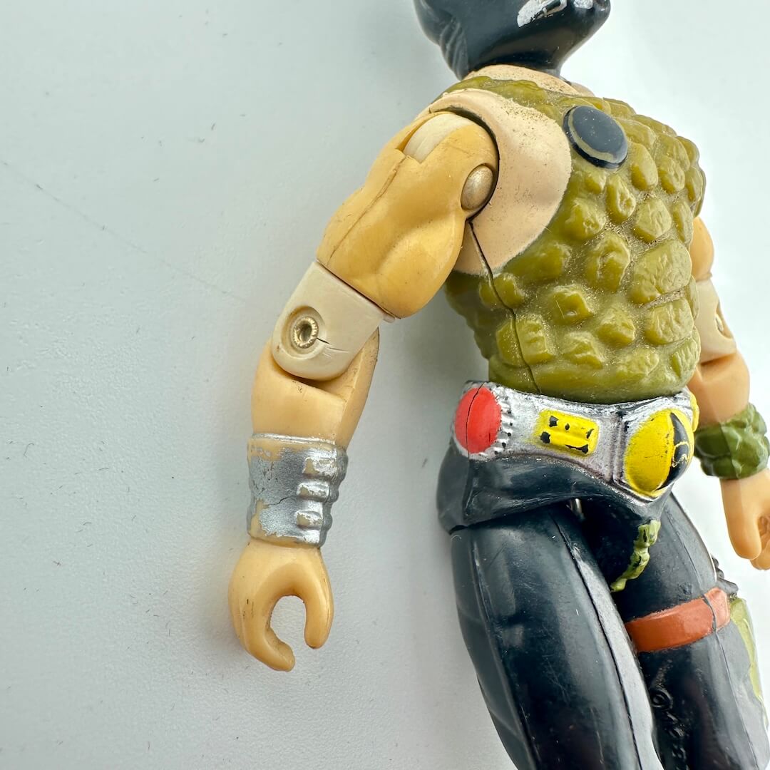 Action figure with green shell, black pants, and yellow belt on a light gray background