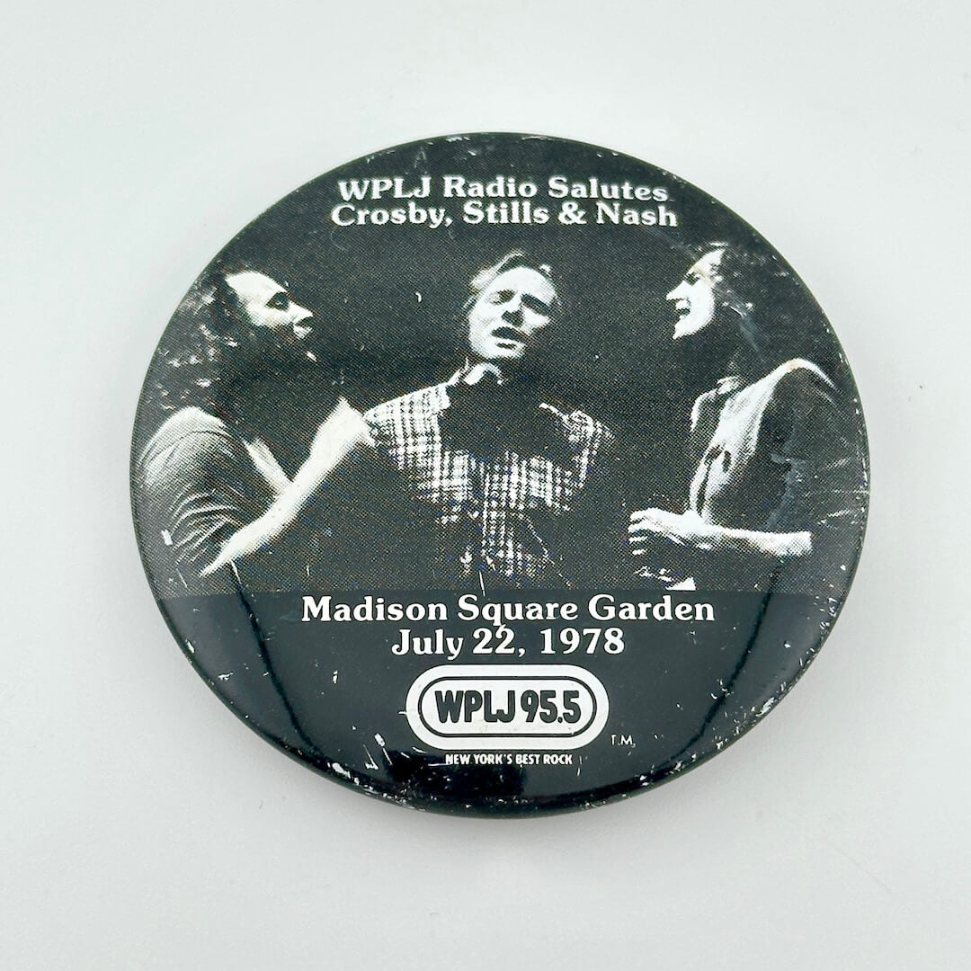 Button/pin with three men singing with text at top and bottom detailing event. 